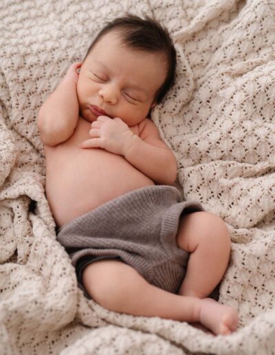 Neugeborenen-Shooting im Atelier: Ein kleiner Strampler, sanfte Farben und ein liebevoller Moment für unvergessliche Erinnerungen.
